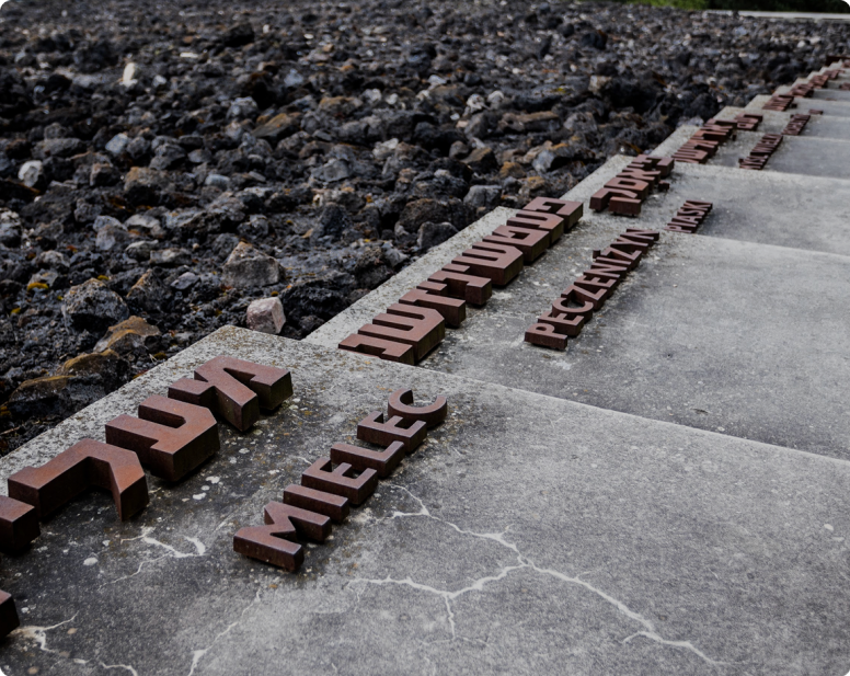 Zdjęcie chodnika z żeliwnymi napisami po polsku i w jidysz: "Mielec", "Peczenizyn"