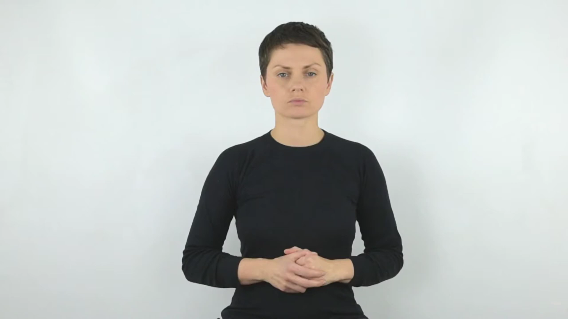 Kobieta o krótkich włosach ubrana na czarno na  białym tle. 