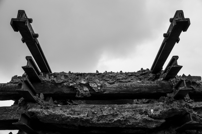 Rzeźba z podkładów kolejowych ułożonych jeden na drugim. 