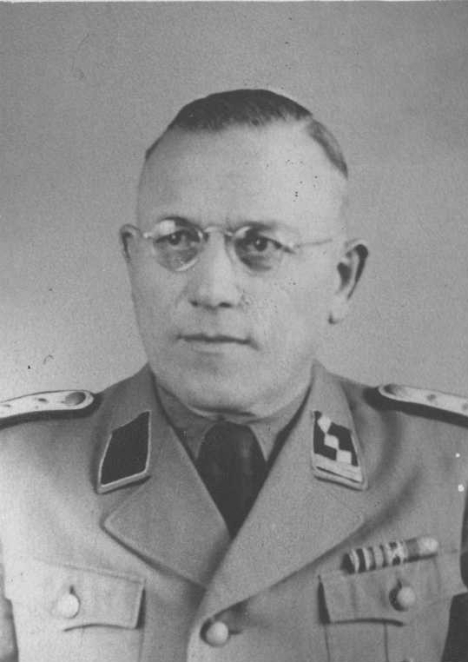 Czarno-biały portret mężczyzny w okularach ubranego w niemiecki mundur.