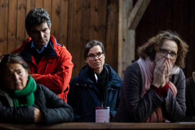 Trzy kobiety oraz mężczyzna, jedna z kobiet zakrywa usta rękami. 