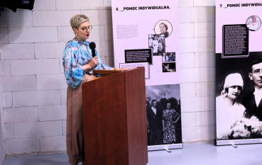 Kobieta przemawia przy mównicy.