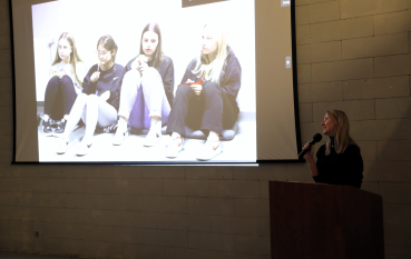 Prelegentka przemawia podczas seminarium, a na ekranie wyświetlony jest slajd prezentacji.