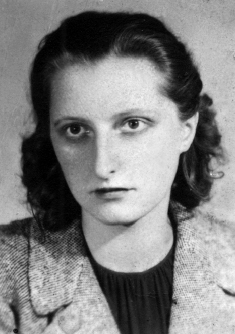 Czarno-biały portret młodej kobiety o ciemnych, pofalowanych włosach sięgających do ramion. Kobieta ma poważny wyraz twarzy i patrzy bezpośrednio w obiektyw. Ubrana jest w ciemną bluzkę oraz jasny żakiet.