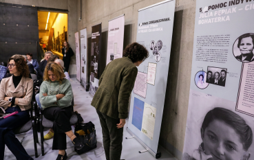 Mężczyzna pochylony nad planszą czyta informacje na jednej z plansz wystawy.