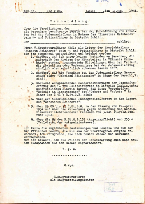 Archiwalny dokument z 18 lipca 1942 roku sporządzony w Lublinie, napisany w języku niemieckim na maszynie. Dokument zatytułowany „Verhandlung” dotyczy zobowiązania do zachowania tajemnicy w związku z realizacją akcji „Einsatz Reinhardt” i przesiedleniem Żydów. Na dole strony znajduje się podpis oraz oznaczenie funkcji oficera SS.