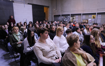 Widok na całą salę wypełnioną siedzącą młodzieżą, która uczestniczy w spotkaniu edukacyjnym.