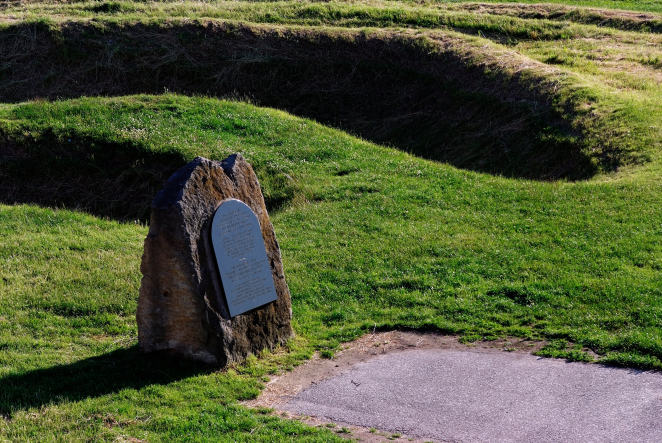 Pomnik upamiętniający ofiary akcji „Erntefest” na Majdanku. W tle rowy egzekucyjne