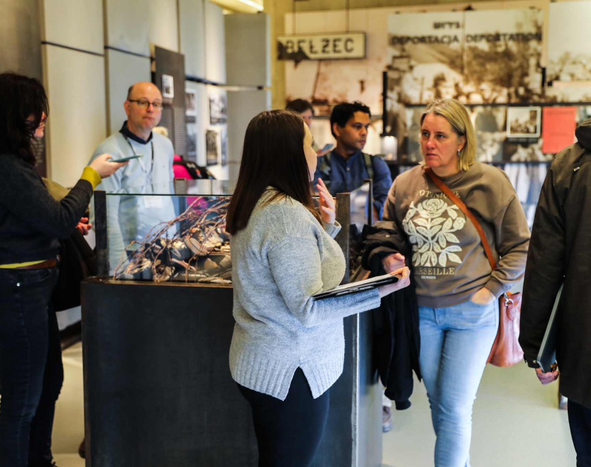 Photograph showing several people at an exhibition. Display boards and cases are visible in the background.