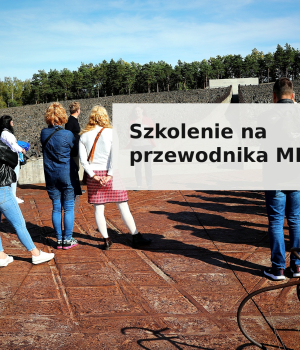 Promotional banner for the guide training course at the Museum and Memorial Site in Bełżec. The photo shows a group of people standing on the grounds of the former death camp, with a stony field, a memorial wall, and a forest visible in the background. The image displays the text "Szkolenie na przewodnika MMPB" ("Guide Training – MMPB") in bold black lettering on a light, semi-transparent background.