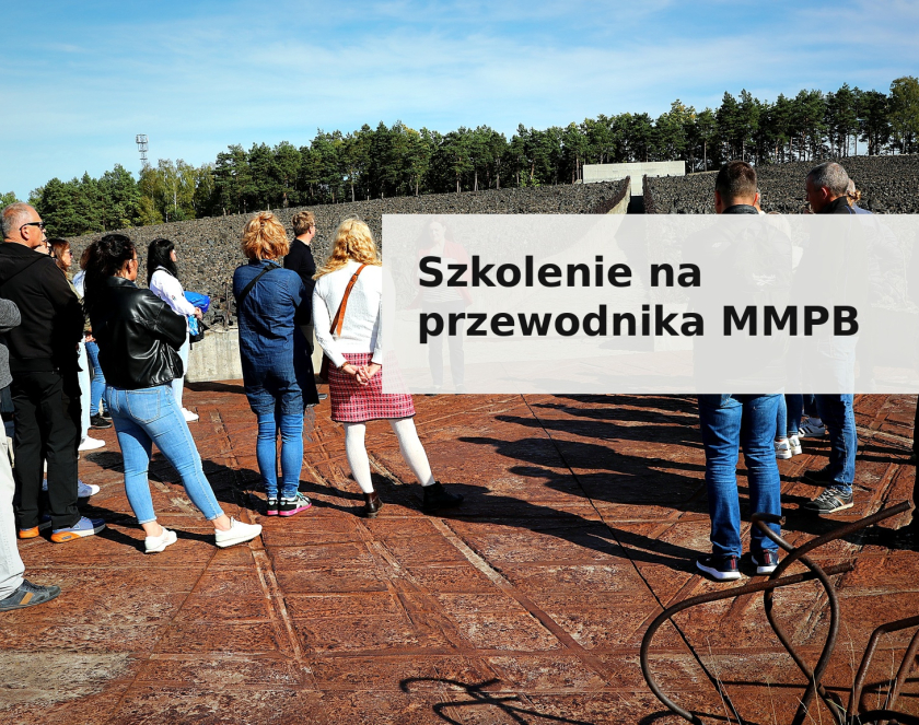 Baner promocyjny szkolenia dla przewodników Muzeum i Miejsca Pamięci w Bełżcu. Na zdjęciu grupa osób stojąca na terenie dawnego obozu zagłady, w tle kamienisty teren i ściana pamięci oraz las. Na zdjęciu widoczny jest napis „Szkolenie na przewodnika MMPB” w czarnej, pogrubionej czcionce na jasnym, półprzezroczystym tle.